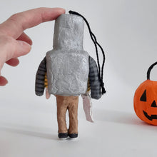 Cargar imagen en el visor de la galería, A spun cotton robot boy ornament being held by a hand, shown from the back. A spun cotton pumpkin bucket sits next to him on a white background.