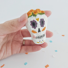 Load image into Gallery viewer, A spun cotton sugar skull, held in hand against a white background. Pic 2 of 5.