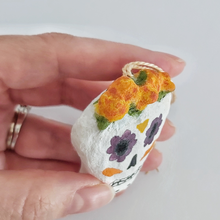 Load image into Gallery viewer, A close up of marigolds on a spun cotton sugar skull ornament. Pic 3 of 5.