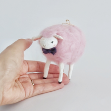 Load image into Gallery viewer, A cotton candy pink needle felted sheep standing on a hand against a white background. Pic 2 of 8.