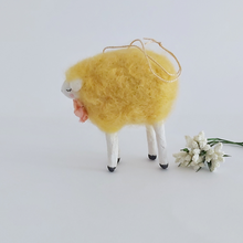 Load image into Gallery viewer, A side view of a yellow, vintage style needle felted spun cotton sheep ornament. White flowers sit behind her, against a white background. Pic 5 of 7.