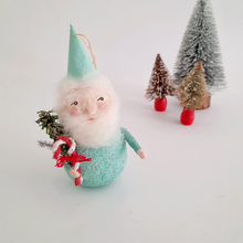 Load image into Gallery viewer, A spun cotton mint green gnome ornament, standing next to small Christmas trees on a white background.