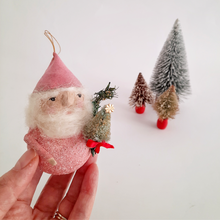Load image into Gallery viewer, Hand holding a small spun cotton gnome ornament with miniature trees in the background
