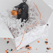 Load image into Gallery viewer, A vintage style spun cotton crow ornament laying in a white gift box filled with white tissue shredding. The box sits on a white background with Halloween confetti. Pic 8 of 8.