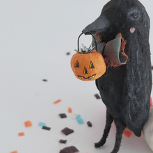 Load image into Gallery viewer, A close up view of a spun cotton jack-o-lantern hanging in the mouth of a spun cotton crow ornament. Pic 3 of 8.