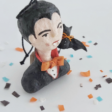 Load image into Gallery viewer, A closer view of a vintage style spun cotton dracula ornament, sitting on Halloween confetti against a white background. Pic 4 of 8.