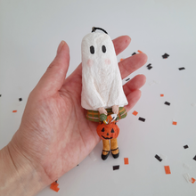 Load image into Gallery viewer, A vintage style, spun cotton ghost girl ornament held in hand over confetti against a white background. Pic 2 of 7.