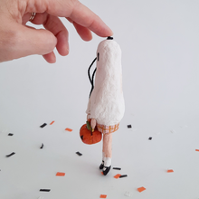 Load image into Gallery viewer, A side view of a vintage style, spun cotton ghost girl ornament over Halloween confetti against a white background. Pic 6 of 8.