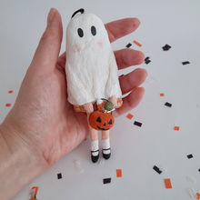 Load image into Gallery viewer, A hand holding a vintage style, spun cotton ghost girl ornament over Halloween confetti on a white background. Pic 2 of 8.