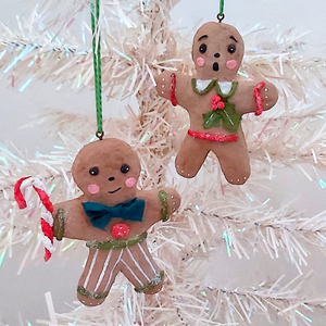 Two vintage style, spun cotton gingerbread man ornaments hanging on a white Christmas tree. Pic 6 of 8. 