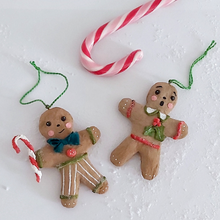 Load image into Gallery viewer, A vintage style spun cotton gingerbread man and gingerbread girl ornaments, laying on a white background. A candy cane lays above them. Pic 8 of 8. 

