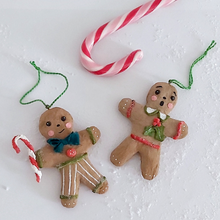 Load image into Gallery viewer, A vintage style spun cotton gingerbread man and gingerbread girl ornaments, laying on a white background. A candy cane lays above them. Pic 8 of 8.