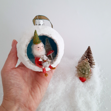 Load image into Gallery viewer, A vintage style, spun cotton gnome diorama ornament held in hand next to two vintage bottlebrush trees. Pic 3 of 5.