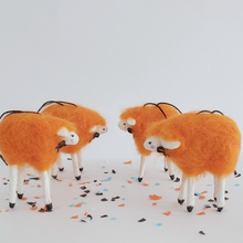 Load image into Gallery viewer, A side view of 4 orange, spun cotton needle felted sheep ornaments. Pic 5 of 5.
