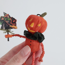 Load image into Gallery viewer, A vintage style, spun cotton pumpkin man ornament held in a hand against a white background. Pic 1 of 8.