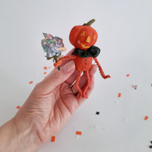 Load image into Gallery viewer, Another photo of a vintage style, spun cotton pumpkin man held in a hand over Halloween confetti on a white background. Pic 2 of 8.