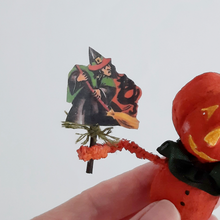 Load image into Gallery viewer, A close-up of a vintage witch illustration held by a spun cotton pumpkin man ornament. Pic 4 of 8.