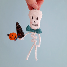 Load image into Gallery viewer, A vintage style, spun cotton pipe cleaner skeleton ornament held against a light blue background. Pic 4 of 5.
