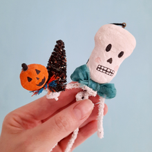 Load image into Gallery viewer, A vintage style, spun cotton pipe cleaner skeleton held in hand against a light blue background. Pic 2 of 5.