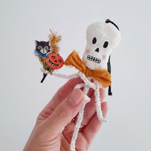Load image into Gallery viewer, A vintage style, spun cotton pipe cleaner skeleton ornament, held in hand against a white background. Pic 2 of 5.