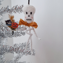 Load image into Gallery viewer, A vintage style, spun cotton pipe cleaner skeleton hanging from a silver tree. Pic 3 of 5.