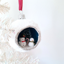 Load image into Gallery viewer, Another view of a vintage style, spun cotton snowmen diorama ornament hanging from a white Christmas tree. Pic 5 of 5.