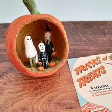 Load image into Gallery viewer, A vintage style, spun cotton trick-or-treaters ornament laying next to a vintage Halloween advert on a wood background. Pic 1 of 7.
