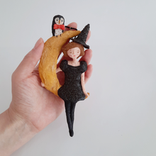 Load image into Gallery viewer, A hand holding a vintage style, spun cotton witch on moon ornament. Pic 2 of 8.
