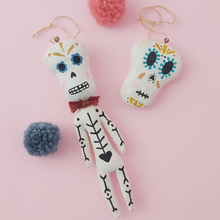 Load image into Gallery viewer, Spun cotton skeleton laying next to spun cotton skull  ornament. Photo 4