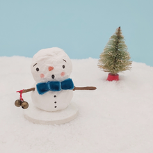 Load image into Gallery viewer, Spun cotton snowman wearing a turquoise velvet bow tie and holding two jingly bells. Pic 1 of 6.