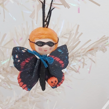 Load image into Gallery viewer, Spun cotton Halloween butterfly girl wearing a bandit mask and carrying a jack o' lantern bucket. Pic 1 of 5.