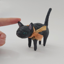 Cargar imagen en el visor de la galería, Size comparison view of black spun cotton cat, finger touching top of ear. Photo 4