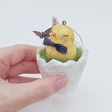 Cargar imagen en el visor de la galería, Side view of a vintage style spun cotton chick sitting in a cracked egg, against a white background. Pic 4 of 6.