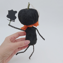 Load image into Gallery viewer, Back view of vintage style spun cotton black jack-o'-lantern, held in hand on a white background. Pic 6 of 8.