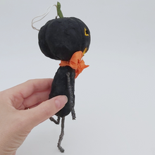 Load image into Gallery viewer, Another side view of vintage style spun cotton black jack-o'-lantern man, held by hand on white background. Pic 7 of 8.