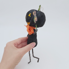 Load image into Gallery viewer, Side view of vintage style spun cotton black jack-o'-lantern on white background and held by hand. Pic 5 of 8.