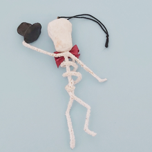 Load image into Gallery viewer, Back side view of a vintage style spun cotton skeleton ornament, against a light blue background. Pic 5 of 6.