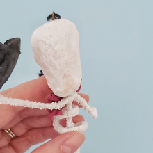 Load image into Gallery viewer, A close up view of the back of the head of vintage style spun cotton skeleton ornament. Pic 4 of 6.