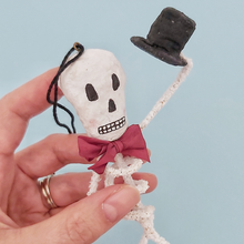 Load image into Gallery viewer, Close view of a vintage style spun cotton skeleton ornament against a light blue background. Pic 3 of 6.