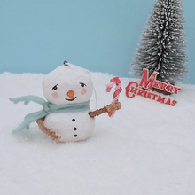 Load image into Gallery viewer, Vintage style spun cotton snowman, holding candy cane and standing on snow against a light blue background. A bottle brush tree and Merry Christmas decoration are in the distance. Pic 2 of 7.