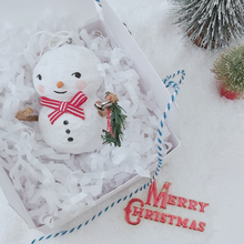 Load image into Gallery viewer, Vintage style spun cotton snowman laying in white gift box with white tissue shredding, next to two bottle brush trees and on a white background. Pic 5 of 7.