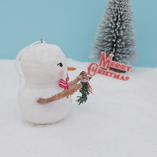 Load image into Gallery viewer, Side view of vintage style spun cotton snowman, against snow and light blue background, with a bottle brush tree and Merry Christmas sign in the distance. Pic 6 of 7.