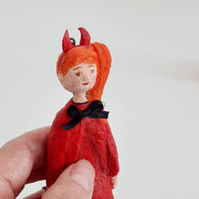 Load image into Gallery viewer, A close up of a spun cotton devil girl ornament, held in a hand against a plain light background.
