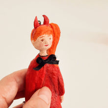 Load image into Gallery viewer, A close up of a spun cotton devil girl ornament, held in a hand against a plain light background.

