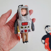 Load image into Gallery viewer, A hand holding a spun cotton robot ornament against a white background. A vintage '80s vampire decoration sits in the background. 

