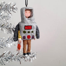 Load image into Gallery viewer, A handmade spun cotton ornament shaped like a child in a robot, hanging from a silver tinsel tree branch against a white wall.
