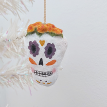 Load image into Gallery viewer, A spun cotton sugar skull ornament, hanging on a tree against a white background. Pic 1 of 5.
