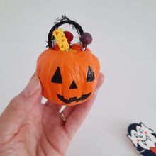 Cargar imagen en el visor de la galería, A hand holds a vintage inspired spun cotton jack-o-lantern bucket filled with spun cotton treats on a white background. A vintage '80s vampire decoration sits in the background. 
