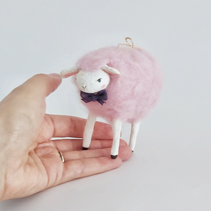A cotton candy pink needle felted sheep standing on a hand against a white background. Pic 2 of 8. 