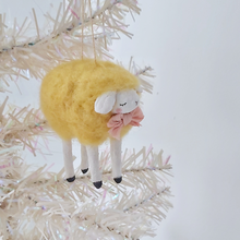 Cargar imagen en el visor de la galería, A yellow, vintage style needle felted spun cotton sheep ornament hanging on a white tree. Pic 3 of 7. 
